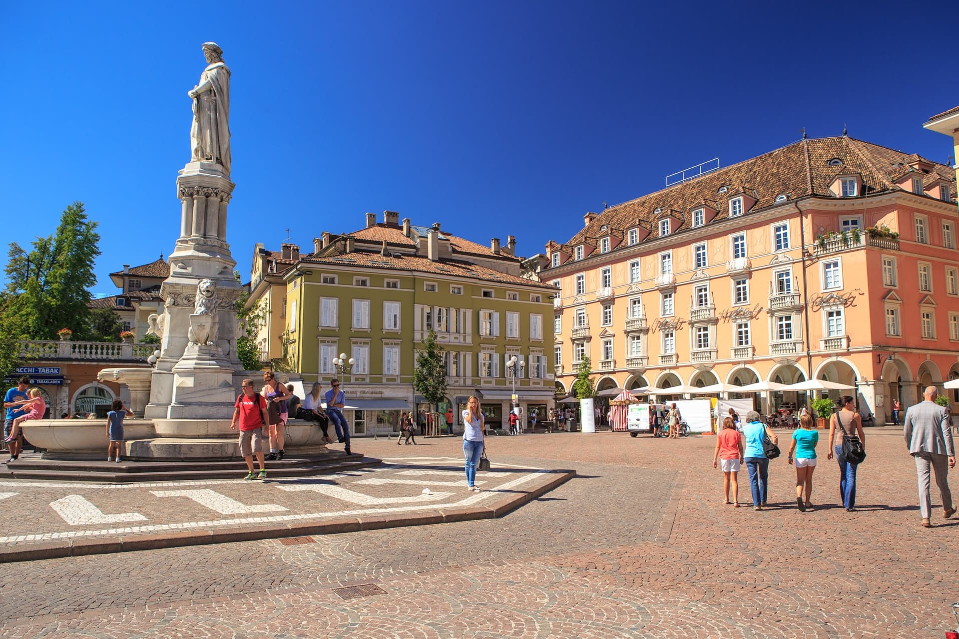 Monumento in Piazza Walther a Bolzano davanti a edifici con arcate